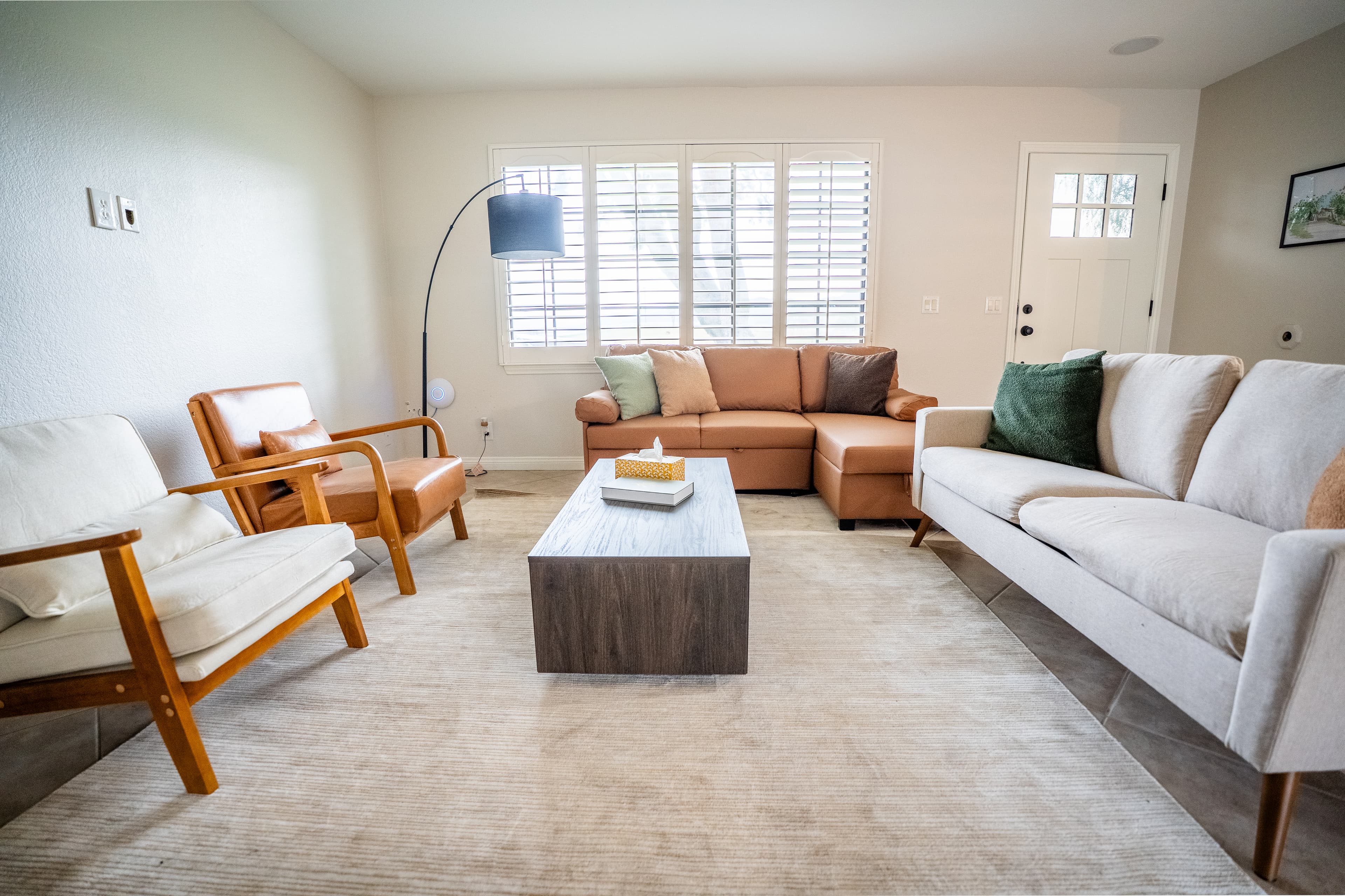 Bright living room with sofas, armchairs, and natural light for overnight stays